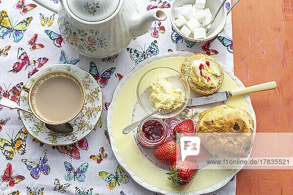 Afternoon tea with scones  clotted cream  strawberries  jam and tea with milk