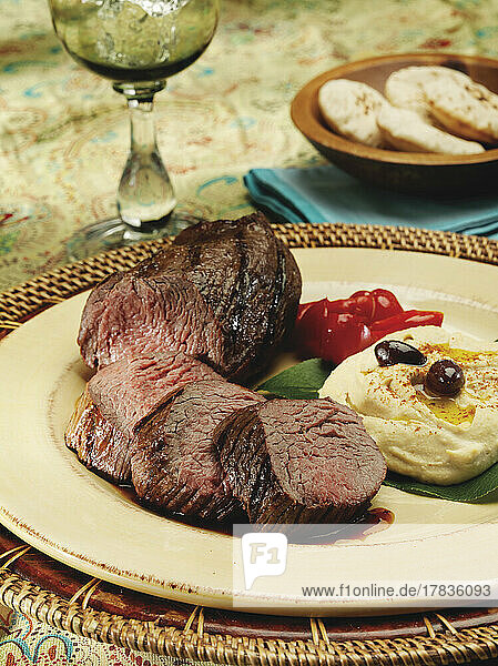 Grilled petite tenderloin of beef with mashed potatoes in a mediterranean setting