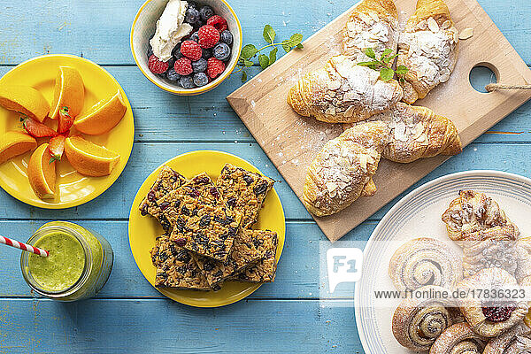 Frühstücksbuffet mit Croissants  Zimtschnecken  Flapjack  Smoothie und Obst