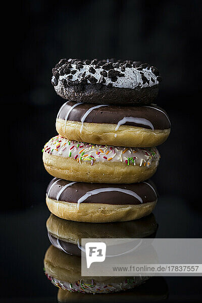 A stack of doughnuts against a black background