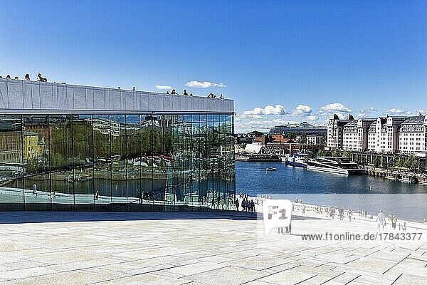 Fußgänger auf dem weißen Vorplatz und Dach der Oper  Architekturbüro Snøhetta  moderne Architektur  Blick von oben auf Oslofjord und Hafen mit Hafenlagerhaus  Stadtteil Bjørvika  Bjorvika  Oslo  Norwegen  Europa