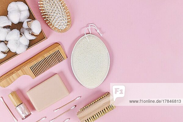 Umweltfreundliche hölzerne Schönheit und Hygieneprodukte wie Kamm und Seife auf rosa Hintergrund