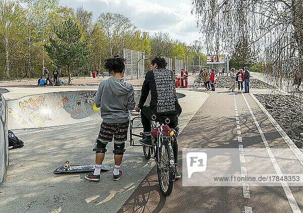 Skateboarder und Radfahrer an einem Skatepool im Park am Gleisdreieck in Berlin-Mitte  Berlin  Deutschland  Europa