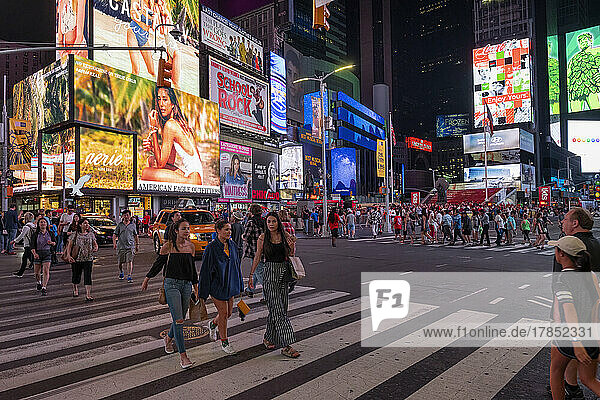 Pedestrians crossing Times Square at night  Manhattan  New York  United States of America  North America
