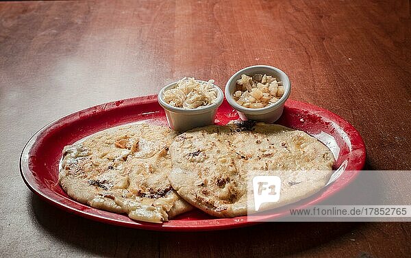 Traditional pupusas served on a wooden table  Closeup of Nicaraguan pupusas served on wooden table. Delicious traditional Salvadoran Pupusas with melted cheese on wooden table