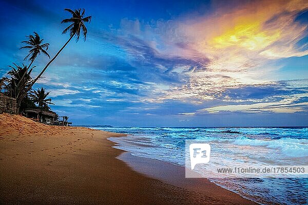 Strandurlaub Urlaub romantisches Konzept Hintergrund  Sonnenuntergang am tropischen Strand mit dramatischen Wolken Himmel. Sri Lanka