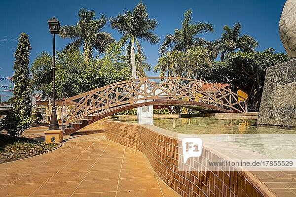 Nagarote Zentralpark. Blick auf einen schönen und entspannten Park mit einem Wasserbrunnen. Traditionelle  Seitenansicht einer kleinen Holzbrücke über einen Wasserbrunnen in einem ruhigen Park. Park von Nagarote  Nicaragua  Mittelamerika