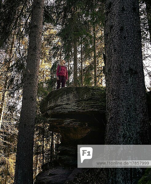 Frau in rot steht auf einem Felsen  Schwarzwald  Deutschland  Europa