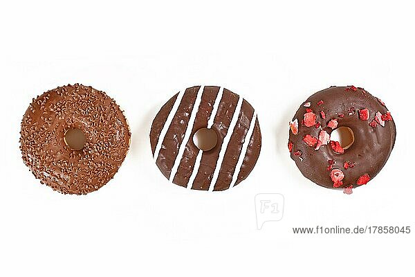 Drei glasierte Schokoladenkekse mit verschiedenen Belägen in einer Reihe auf weißem Hintergrund