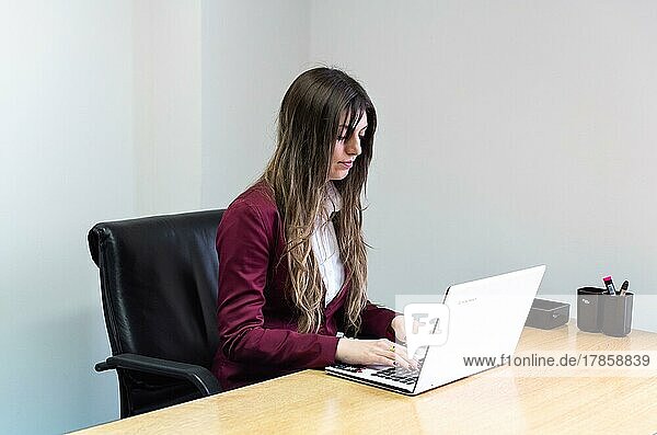 Porträt einer Frau  die an ihrem Laptop arbeitet
