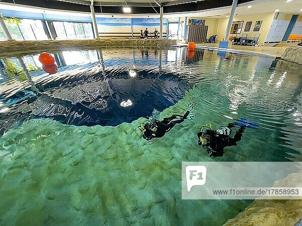 Paar von Taucher taucht schwimmt dicht unter Wasseroberfläche in klares Wasser von Indoor Tauchturm  Indoor Dive-Centre Tauchzentrum Dive4Life  Siegburg  Nordrhein-Westfalen  Deutschland  Europa