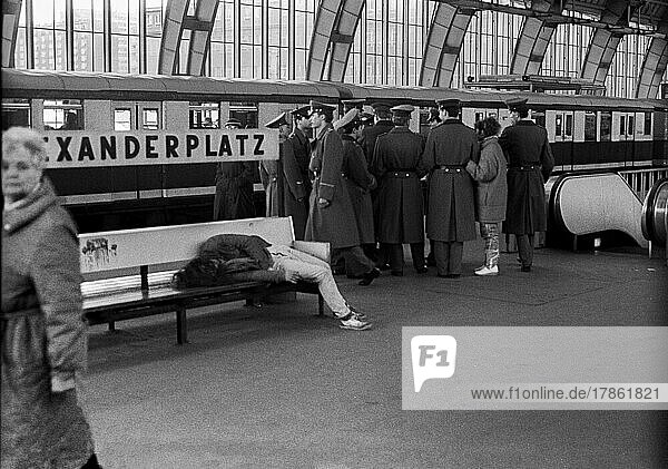 GDR  Berlin  14. 3. 1988  drunken man on a bench at Alexanderplatz station  group of NVA soldiers