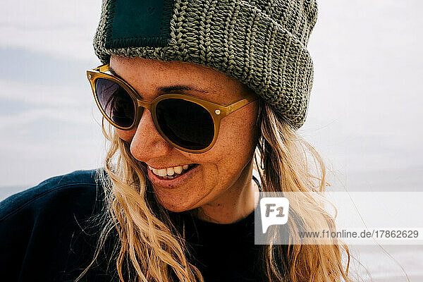 close up portrait of freckly woman with sunglasses on at the beach