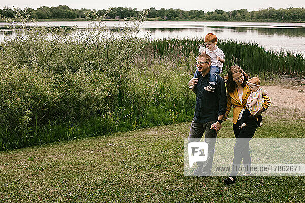 Family of father  mother  son and daughter walk along lakeside