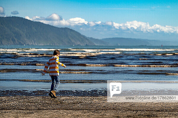 a boy playing on the beach shore in Northern California