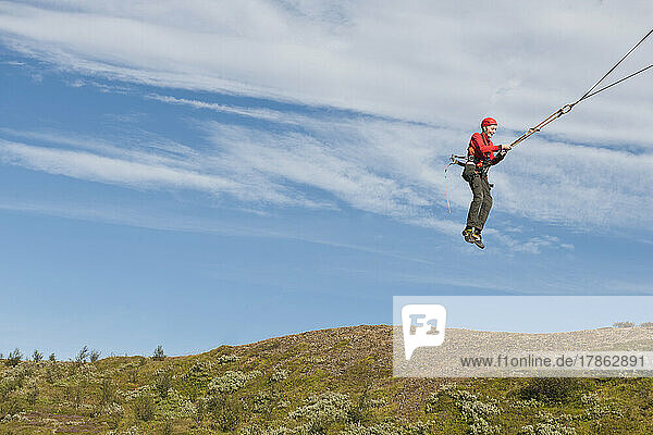 boy using a giant swing at high rope access course in Iceland