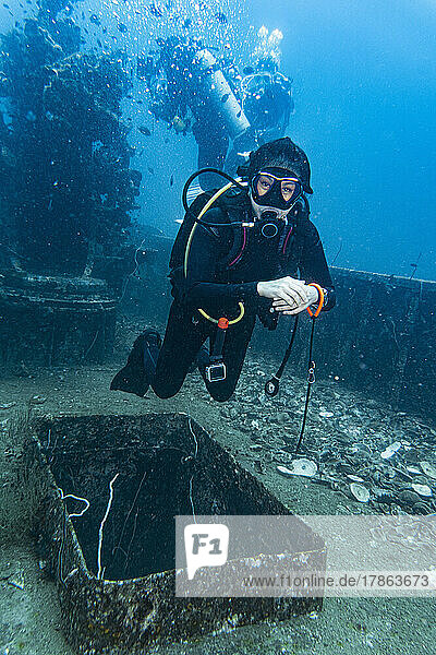 diver exploring the wreck of the HTMS Sattakut in Thailand