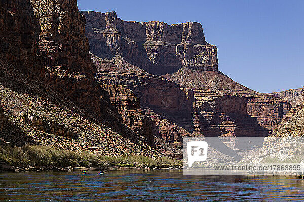 Two kayakers paddling down through the Grand Canyon