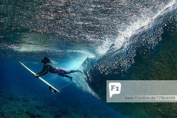 Underwater view of male surfer making duck dive