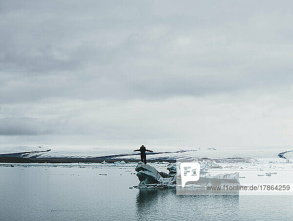 woman meditating near lake with iceberg