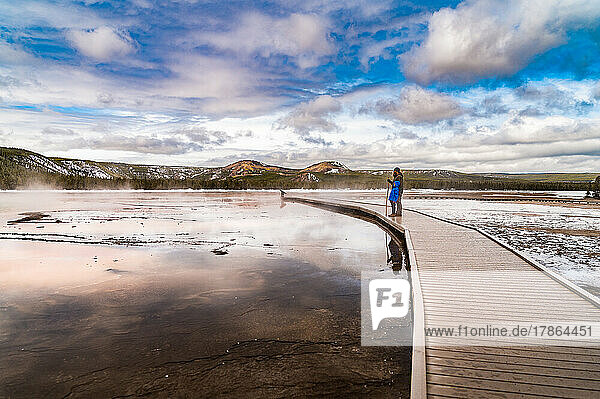 a father and son standing on a boardwalk at grand prismatic spring