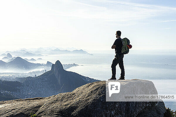Climber enjoying beautiful view to city from rocky mountain top