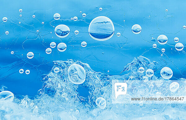 Small bubbles trapped under the ice in the brilliant blue water