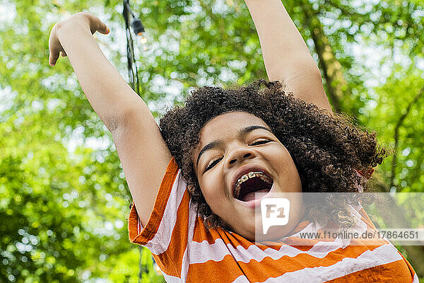 Child in backyard jumping for joy