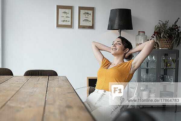 Woman sitting at dining table at home relaxing