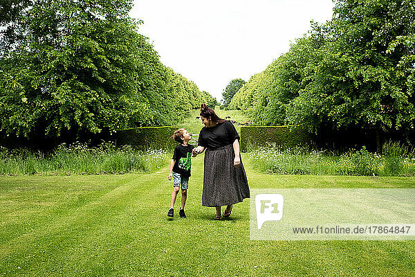mother and son happily walking in a beautiful English garden