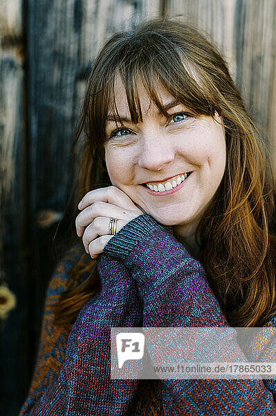 portrait of a smiling woman in a handmade knit sweater