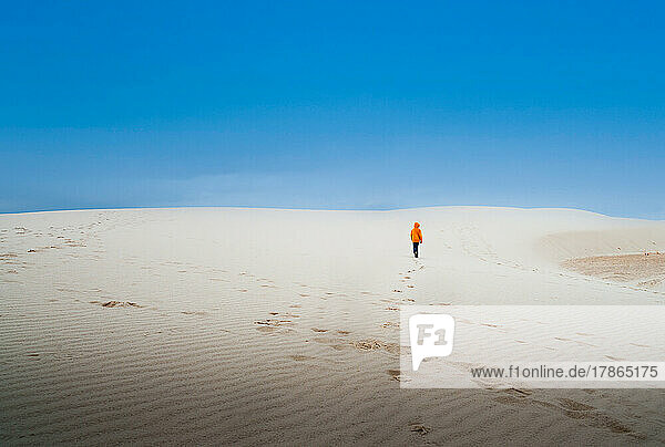 a boy walking across the sand dunes in New Mexico