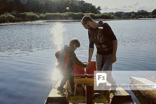 father and son enjoy adventure on watercraft catamaran