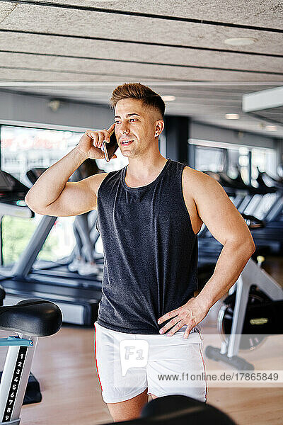 Male athlete talking on mobile phone at gym