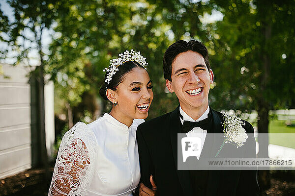 Multiracial groom and bride laughing after wedding ceremony