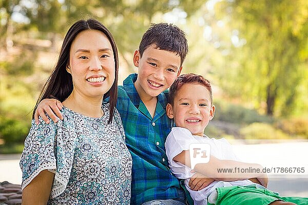 Outdoor portrait of biracial chinese and caucasian brothers and their mother