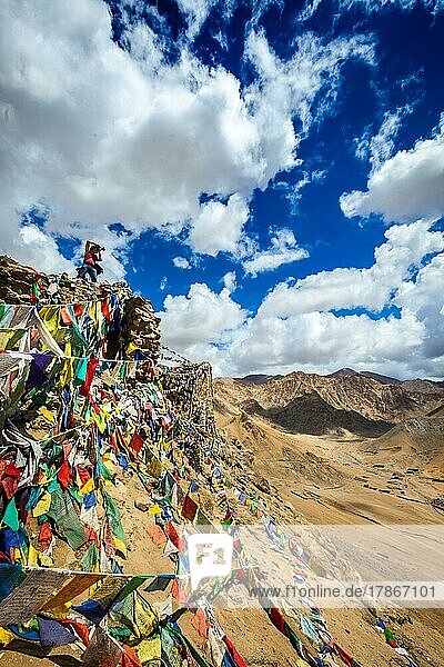 Reisefotograf fotografiert in den Bergen des Himalaya auf einer Klippe mit buddhistischen Gebetsfahnen. Leh  Ladakh  Jammu und Kaschmir  Indien  Asien
