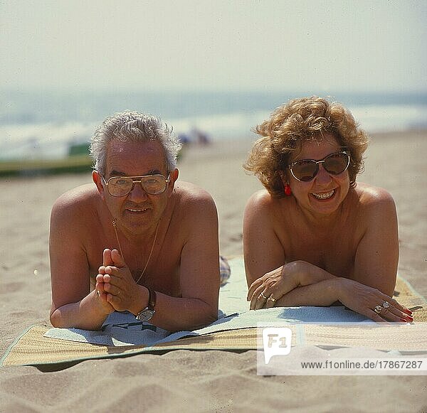 Older married couple on the beach  recumbent with the solar bath  sand beach  Older married couple on the beach  recumbent with the solar bath  sand beach