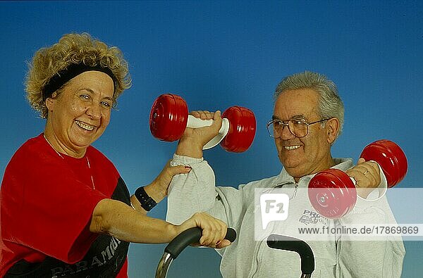 Älteres Paar  Heimtraining mit Fahrrad und Hanteln Hometrainer