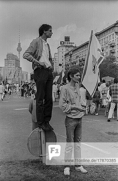 DDR  Berlin  01. 05. 1987  1. Mai Kundgebung 1987 auf der Karl-Marx-Allee  Jugendlicher steht auf einem Verkehrsschild