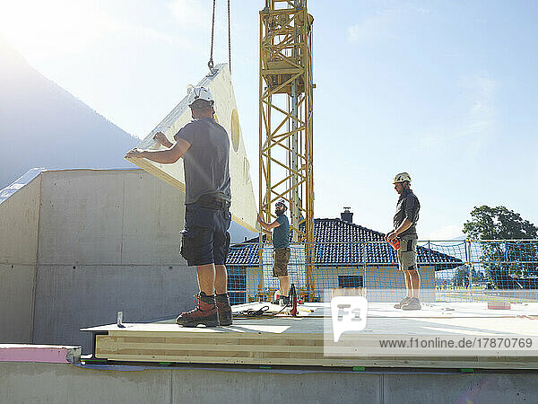 Carpenters working at construction site on sunny day