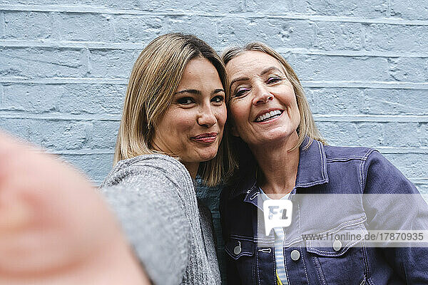 Lächelnde Frau  die ein Selfie mit ihrer Mutter macht