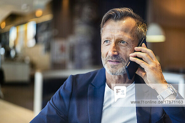 Contemplative businessman talking on smart phone