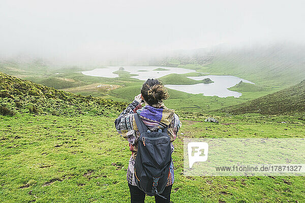Woman with backpack standing at volcanic crater Corvo  Azores  Portugal