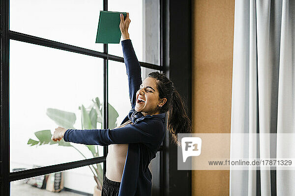 Cheerful businesswoman with diary shouting in office