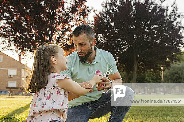 Father talking with daughter at park