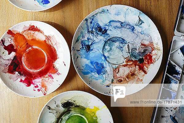 Watercolors in plates on table at home