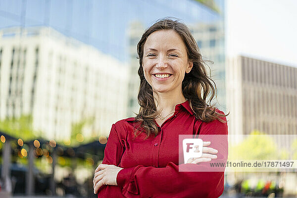 Happy woman with arms crossed wearing red shirt