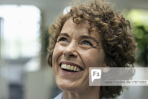 Cheerful businesswoman with brown curly hair