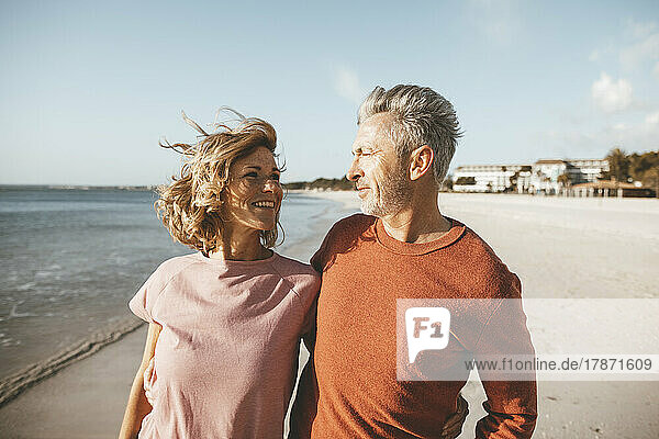 Happy mature couple at beach on sunny day
